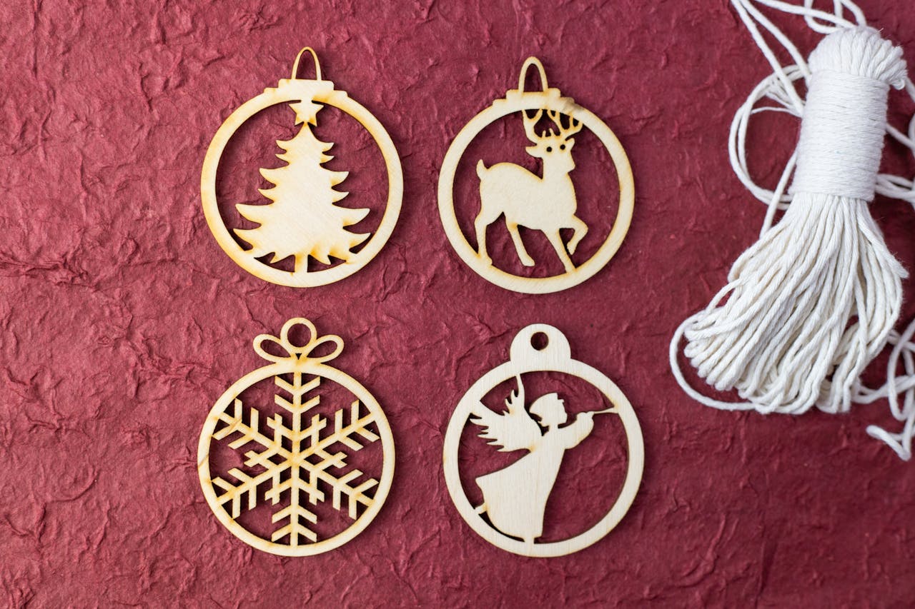 services-01 Flat lay of wooden Christmas ornaments featuring tree, reindeer, angel, and snowflake on a textured red background.